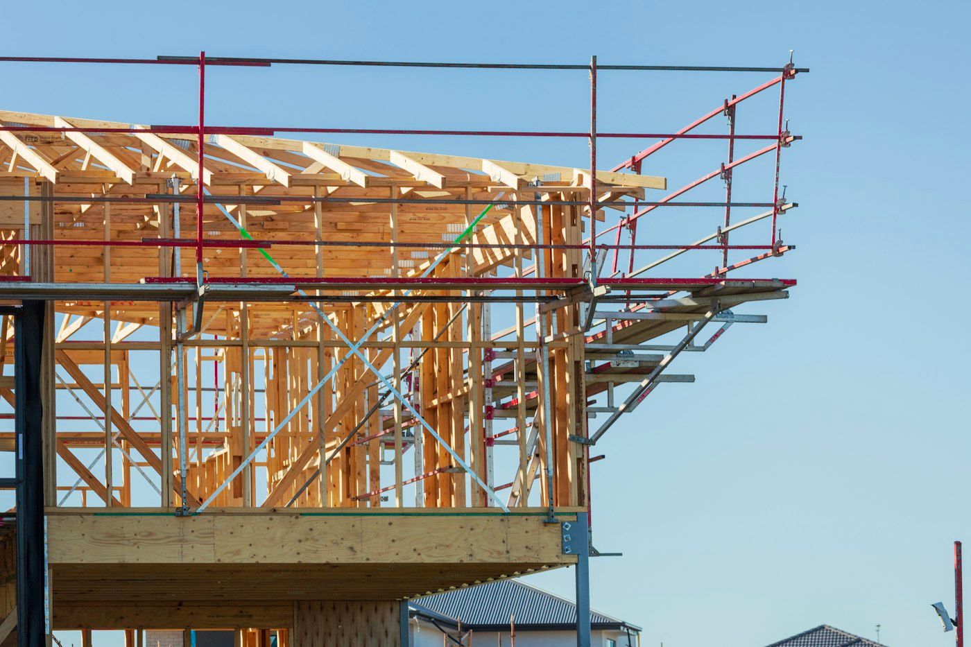 Second-floor framing over a garage with scaffolding and guardrails