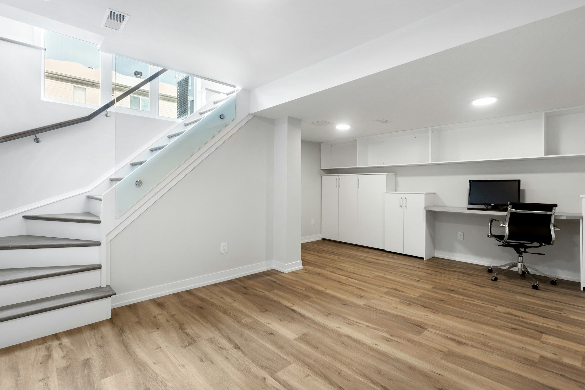 Finished basement with an open stair and a built-in desk