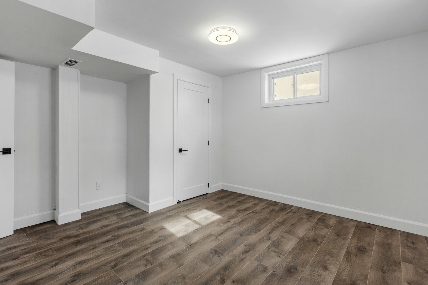 Finished basement bedroom with a soffit over the closet wall and an LVP floor