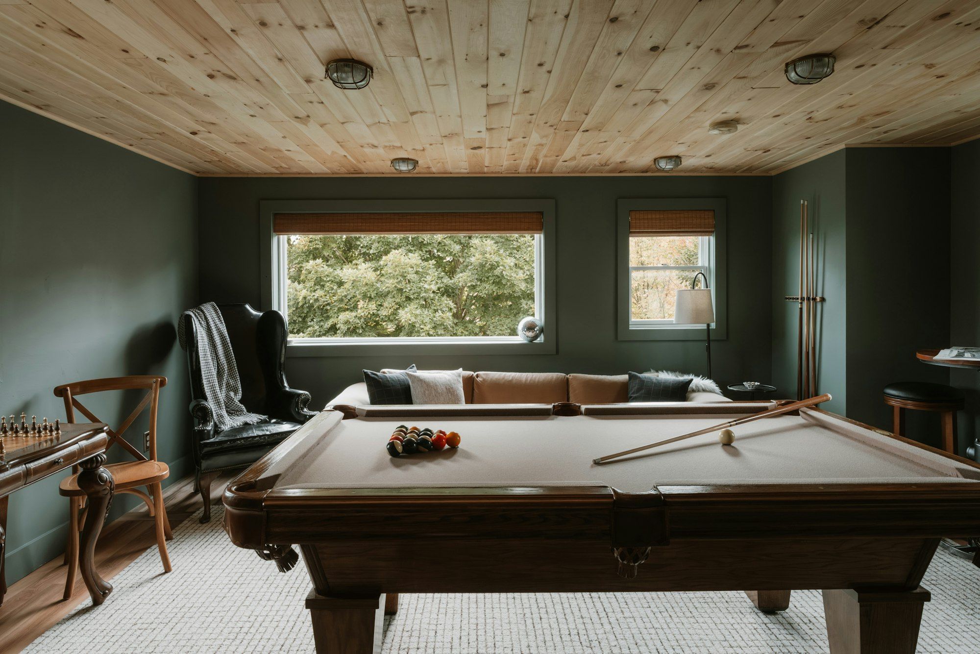 Walkout basement game room with a pool table and a pine ceiling