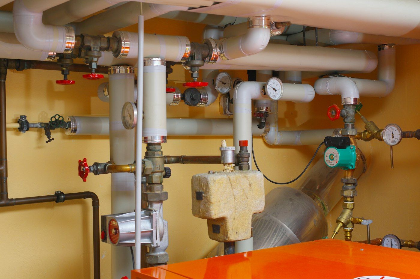 Boiler pipes and valves on a basement wall