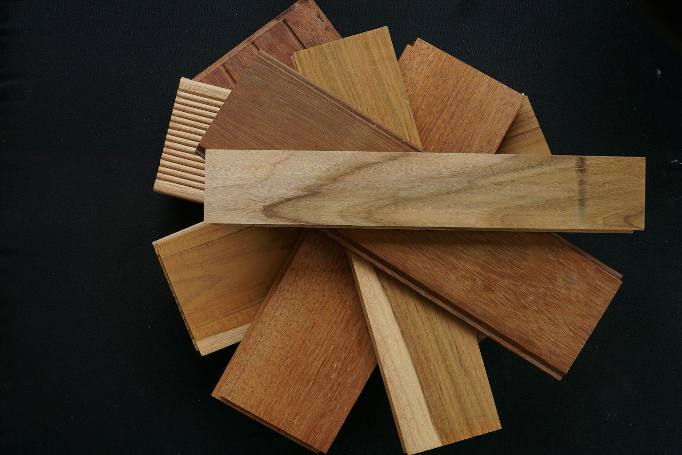 Fan of oak, teak and walnut sample boards on a black table