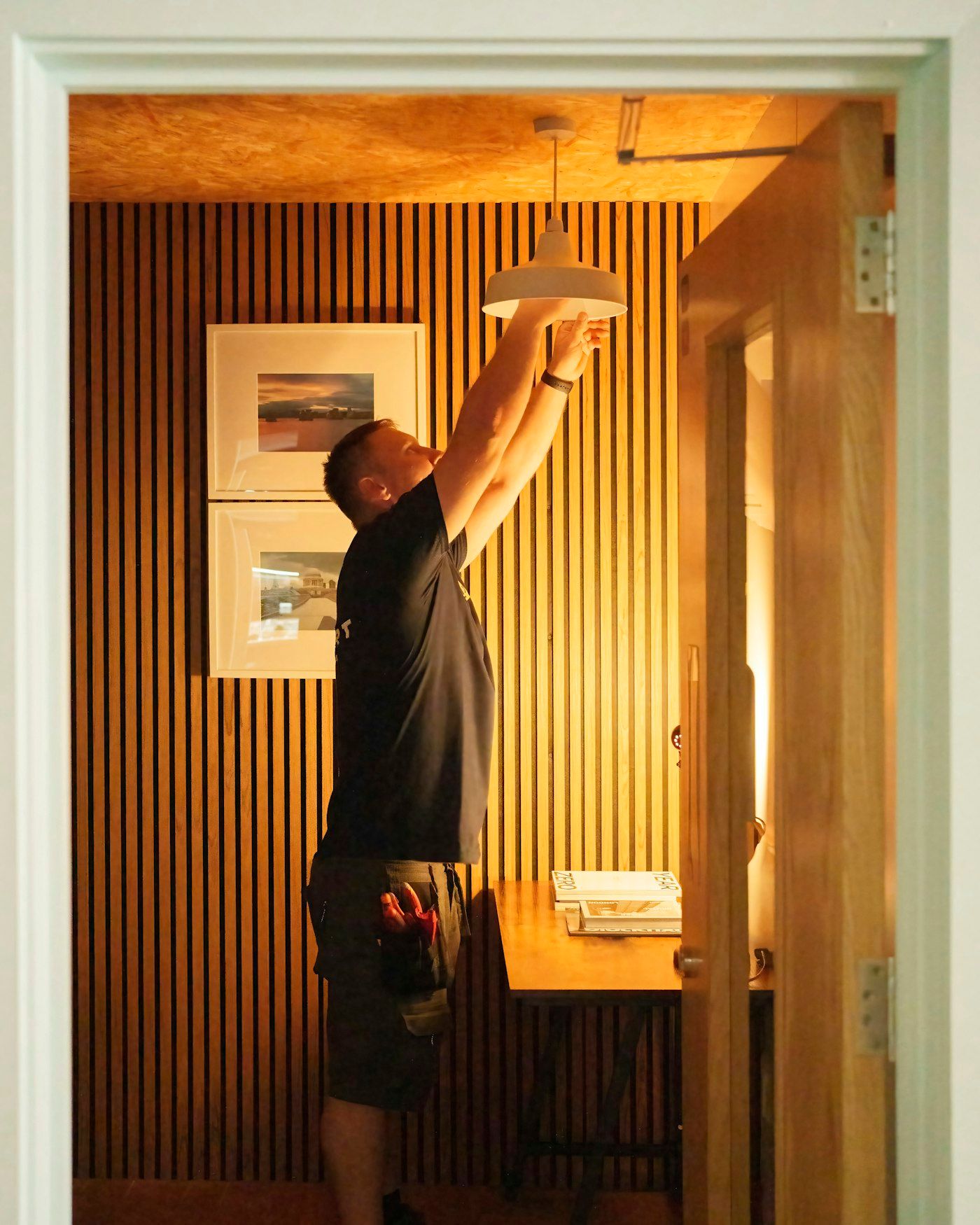 Kyle installing a ceiling fixture in a finished room