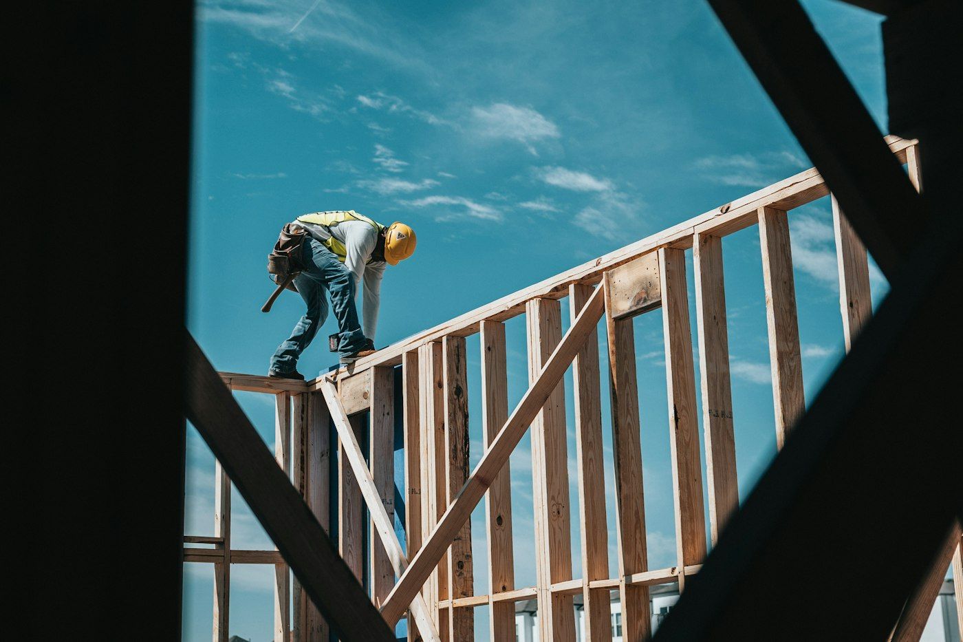 Tomás standing on a new wall plate during addition framing