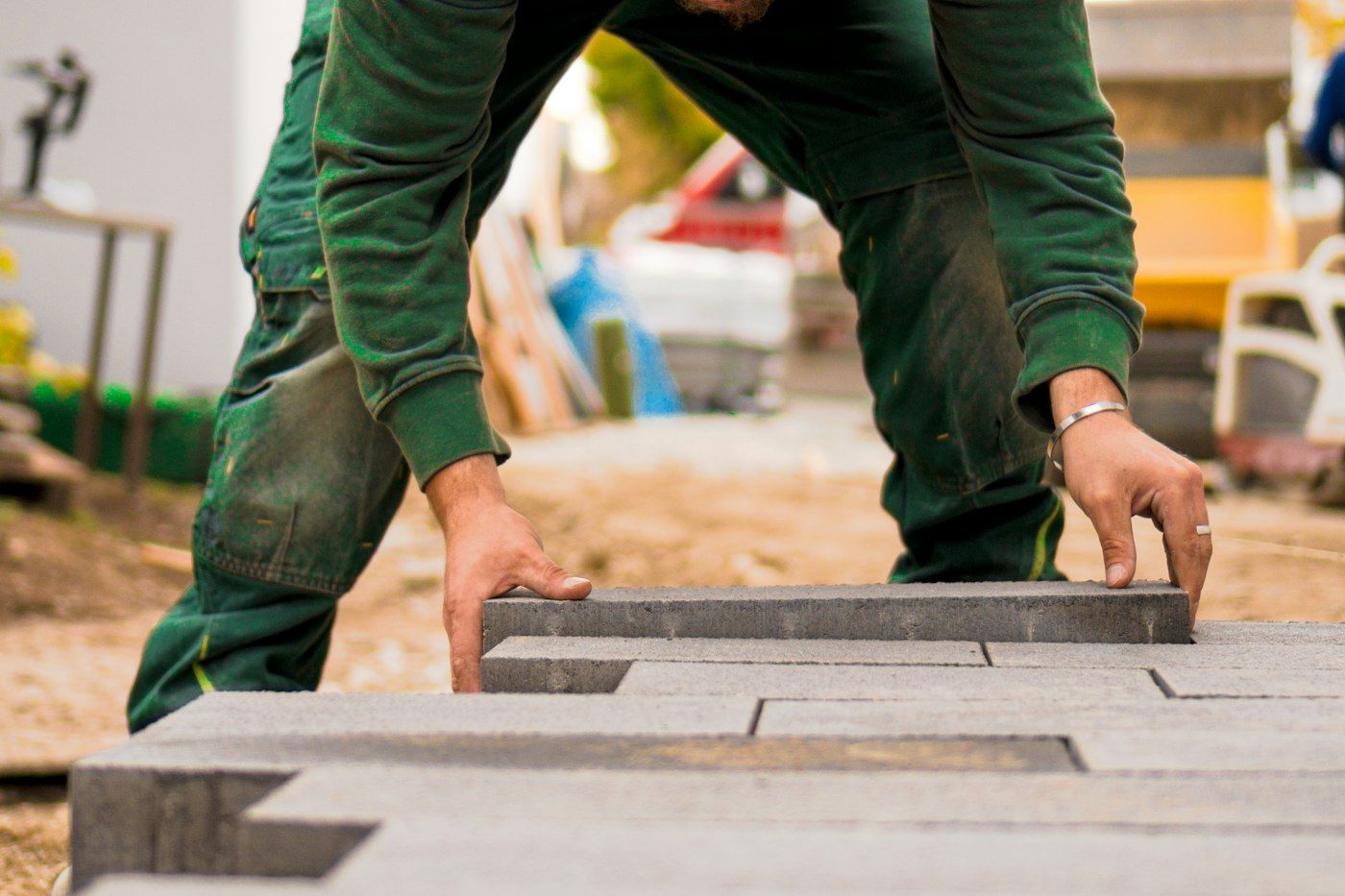 Installer setting a large-format paver into place by hand