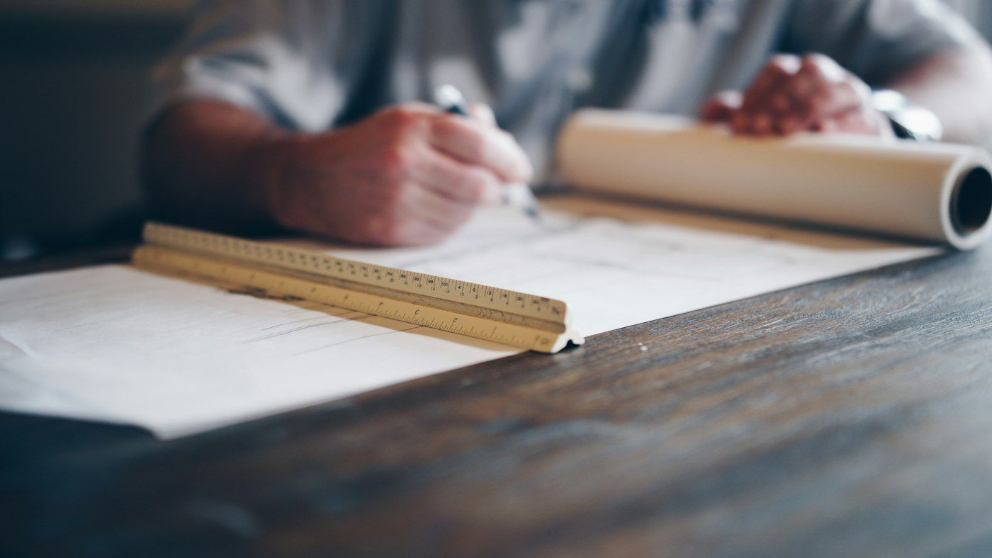 Dana drafting a kitchen elevation with a scale ruler