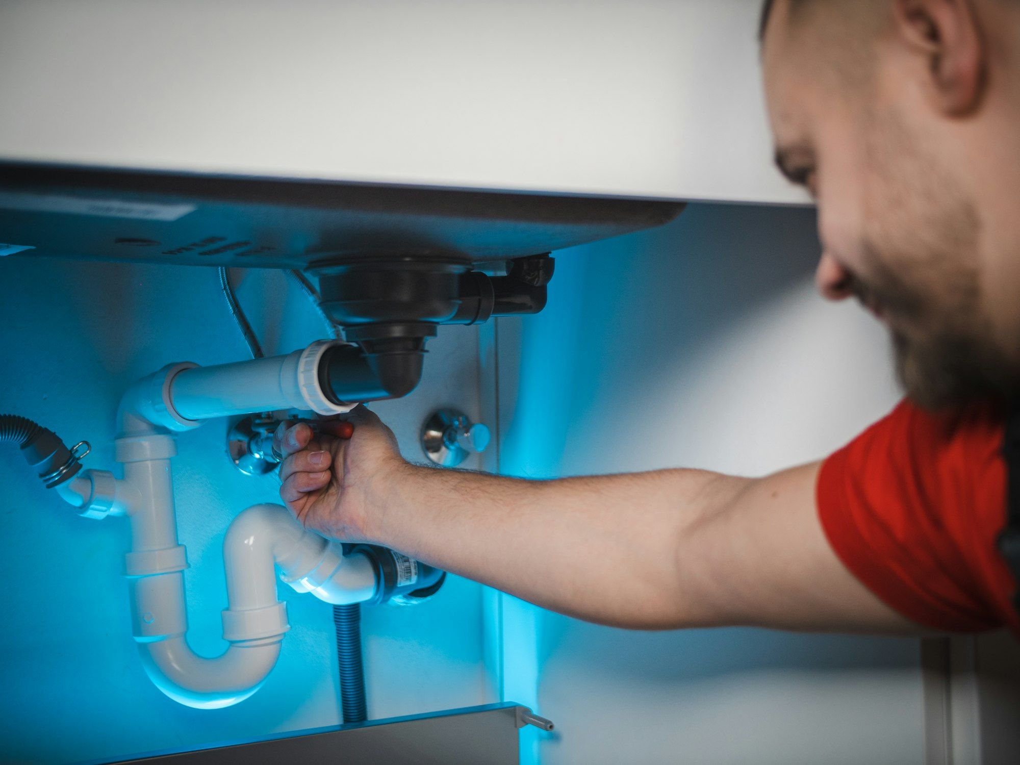 Plumber loosening a sink trap