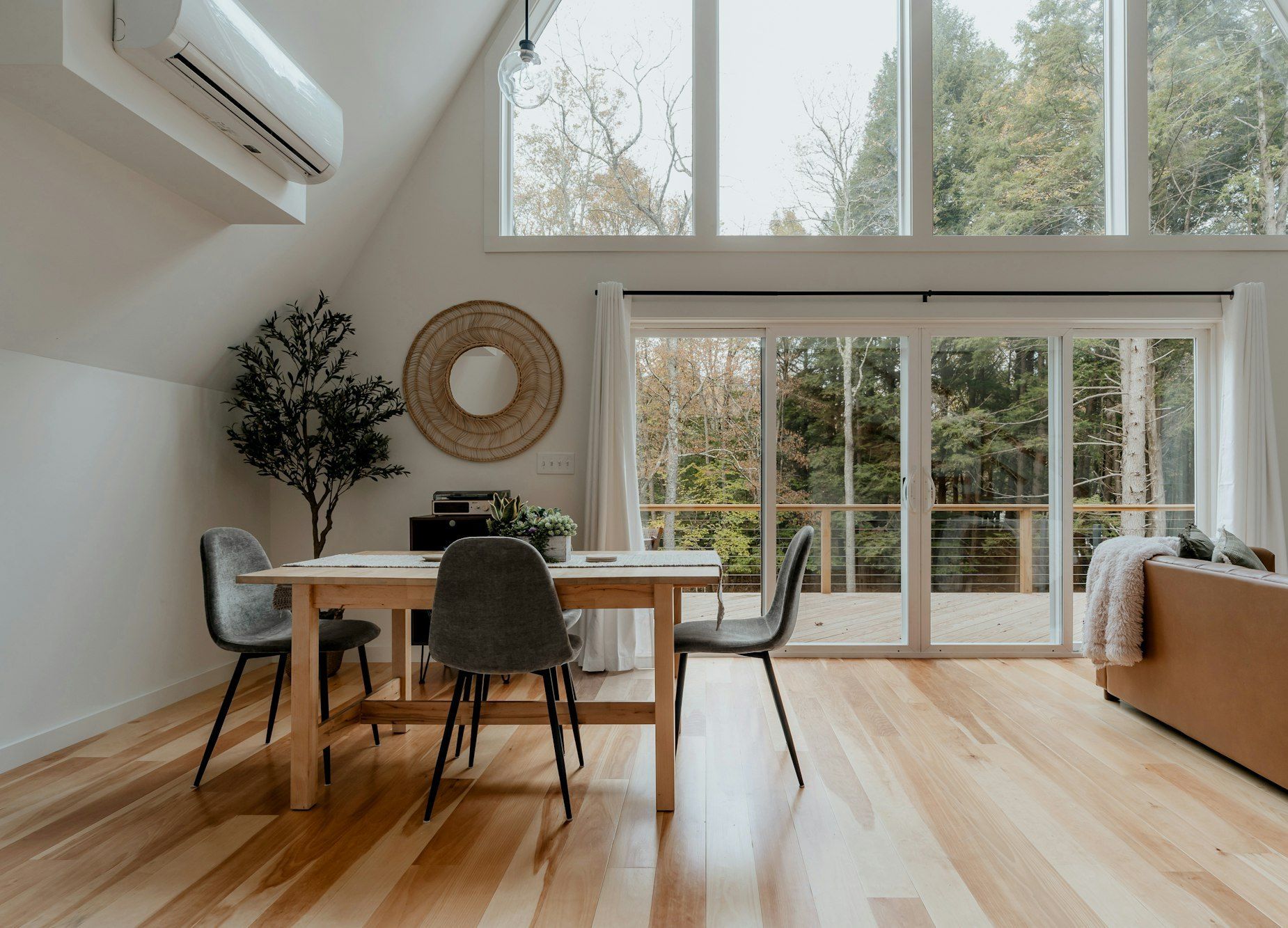 A-frame dining area with tall windows and light maple plank floor