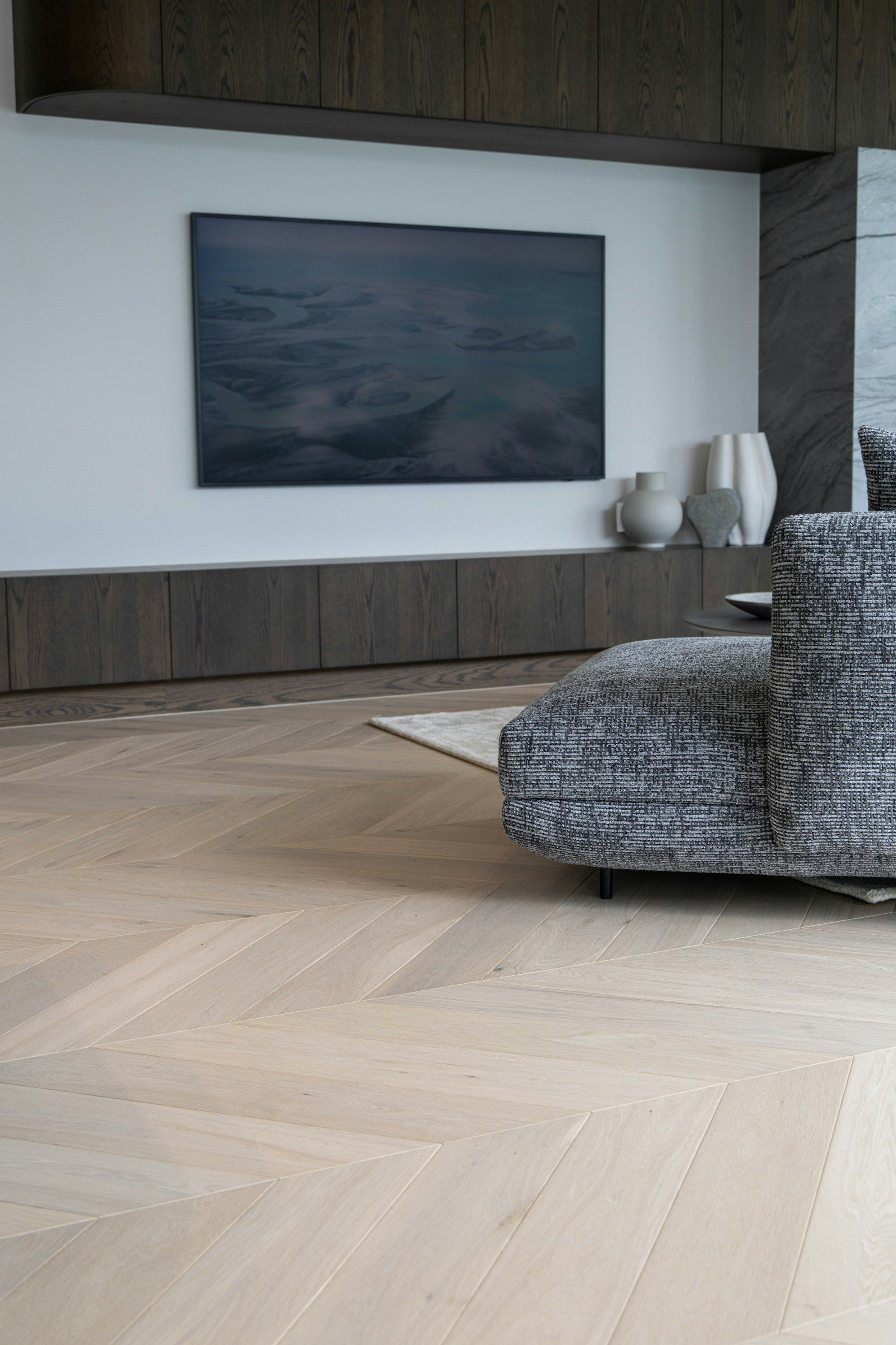 Living room with pale chevron oak floor and gray sofa