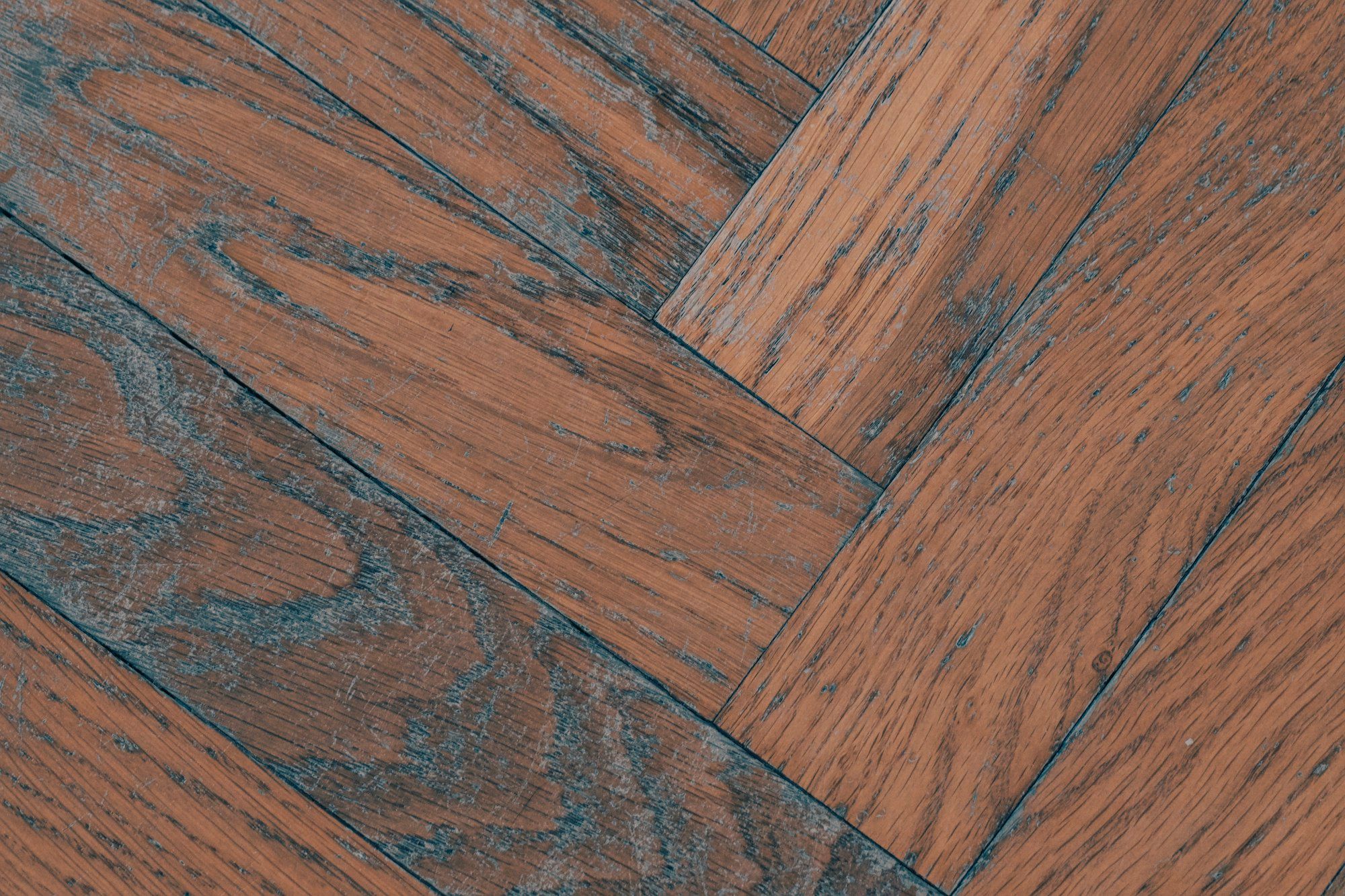 Close view of brown herringbone planks with gray wire-brushed grain