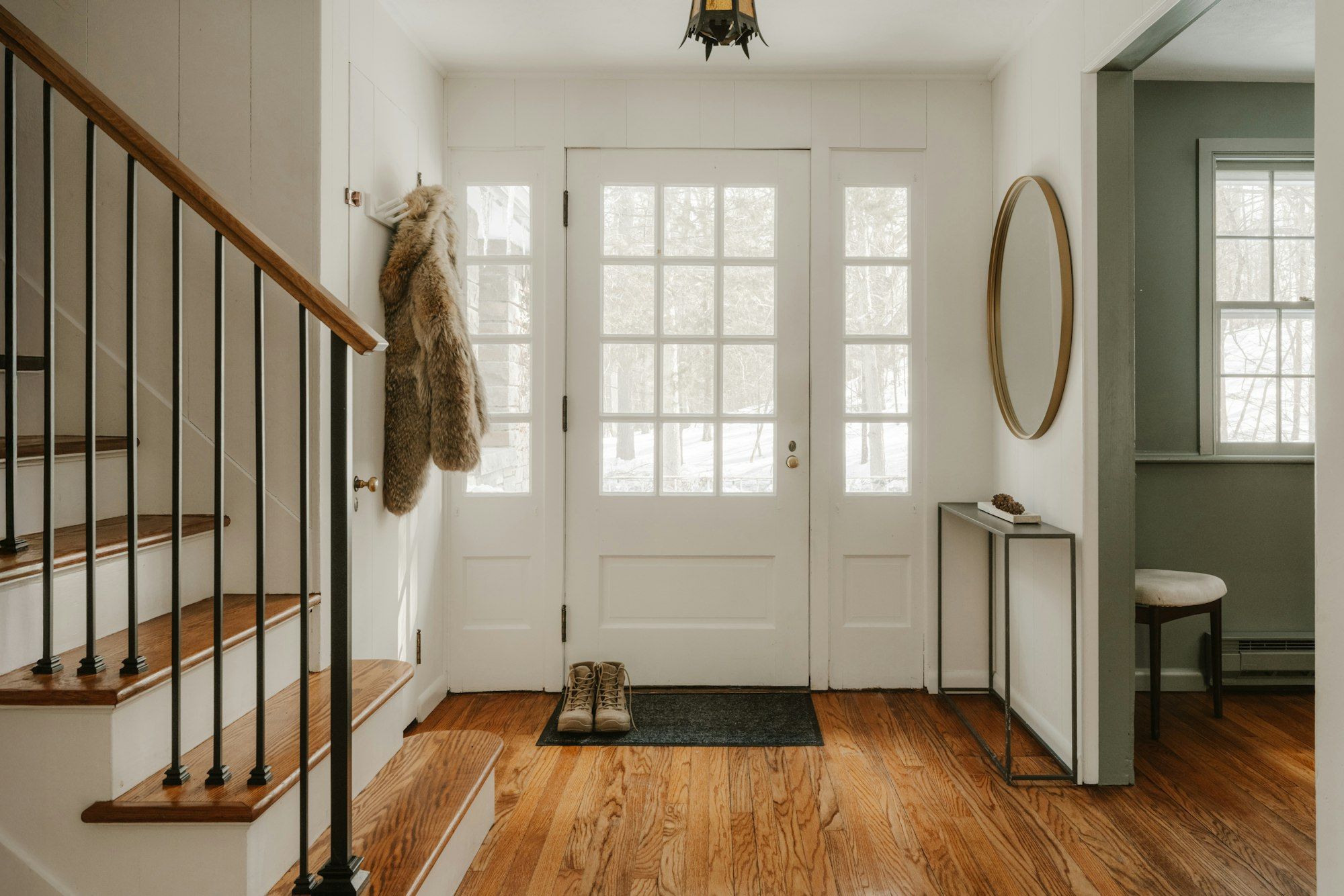 Front hall with red oak floor and stair treads, white risers and black balusters