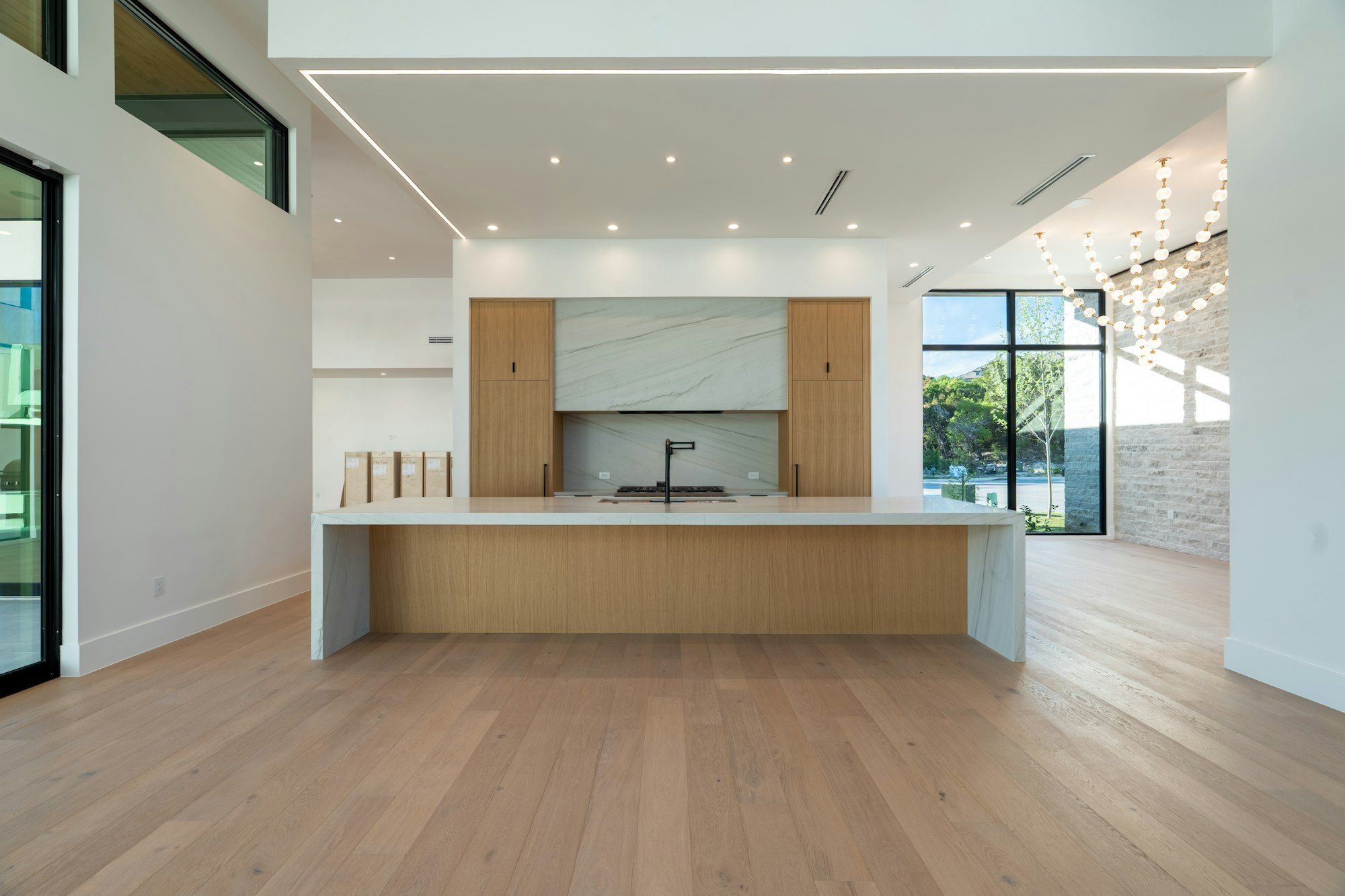 Open plan kitchen with a long oak-fronted island and wide light oak planks
