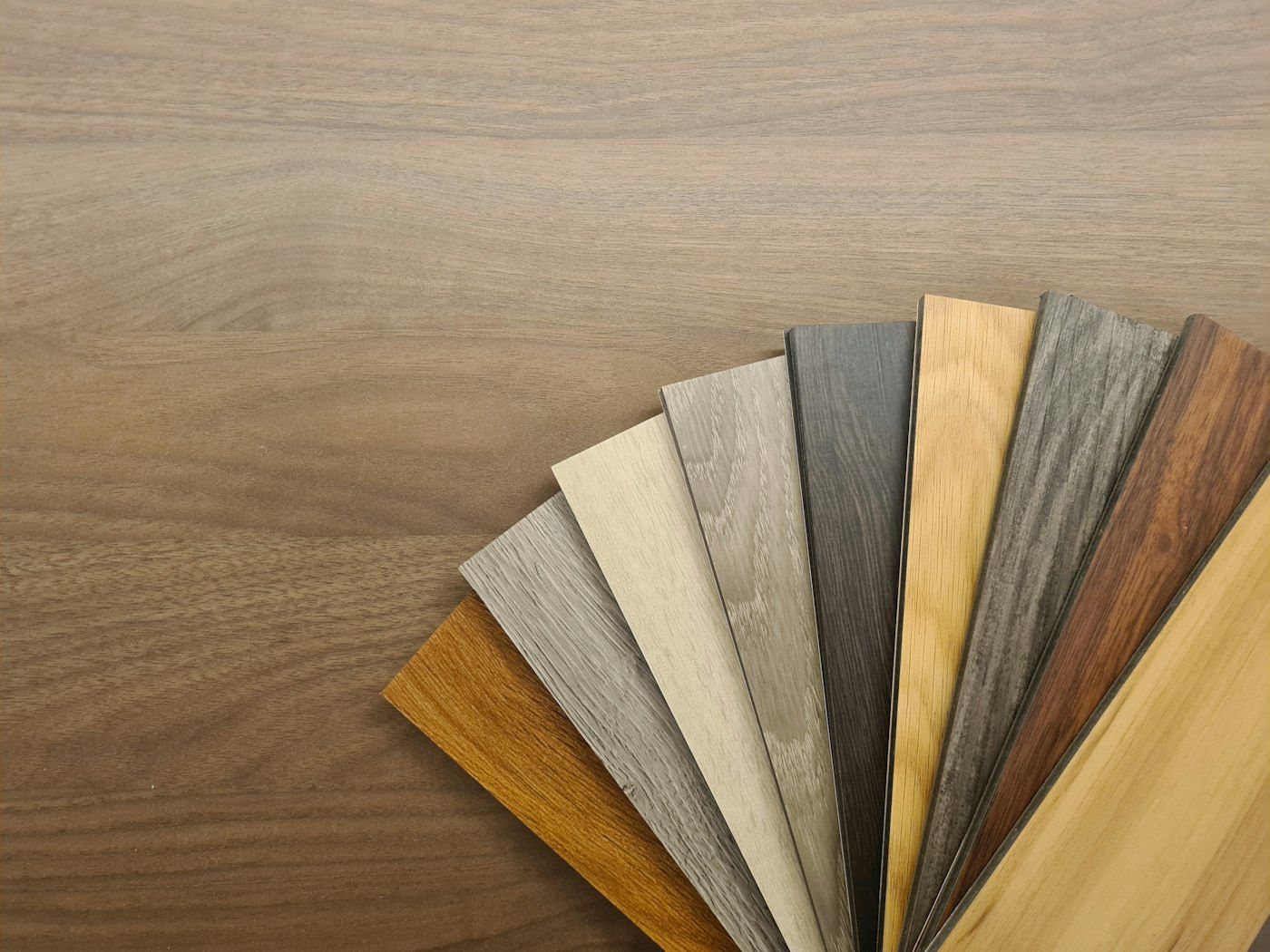Fan of flooring sample planks from pale oak to dark walnut tones