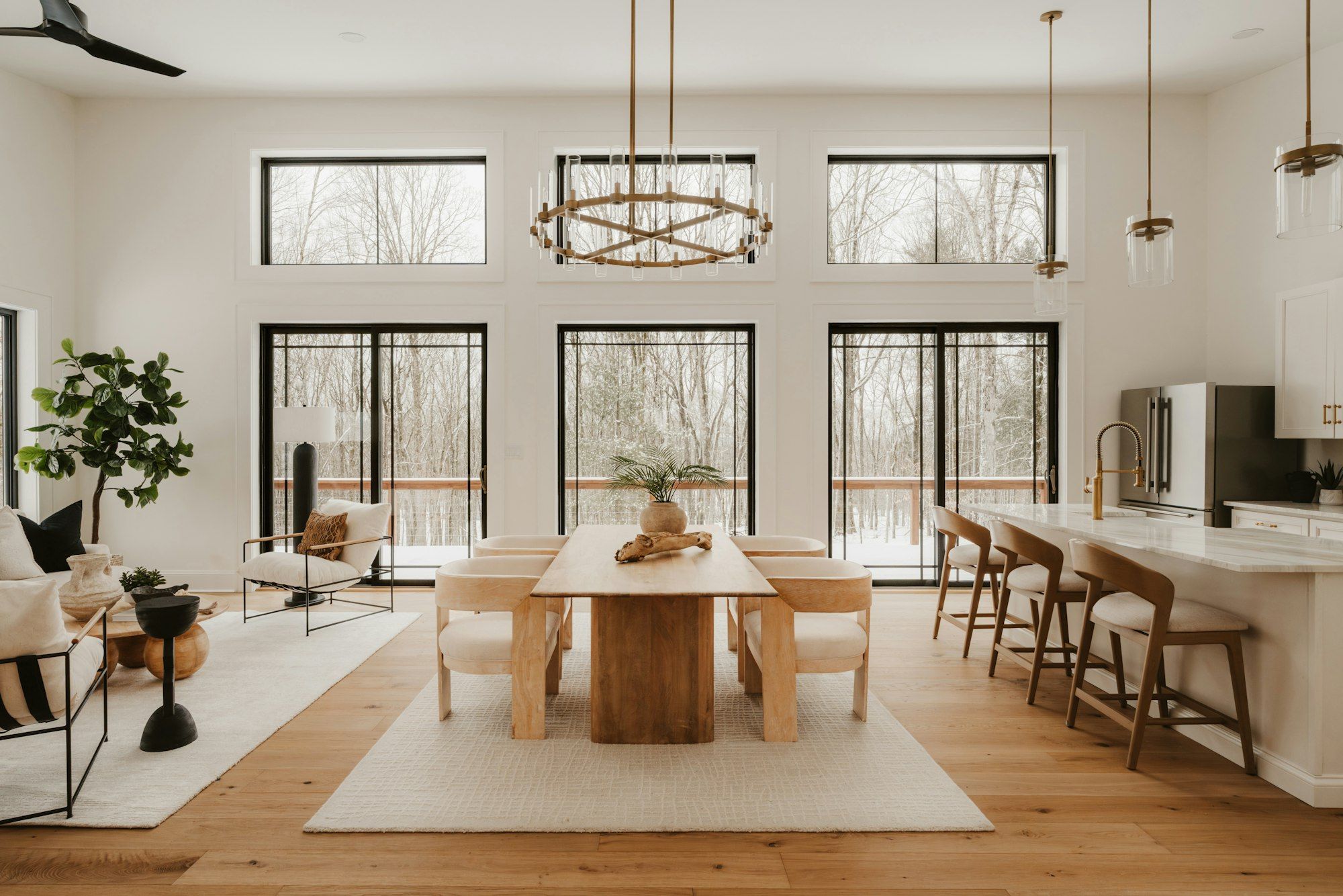 Open dining room and kitchen with wide plank white oak floors and tall windows
