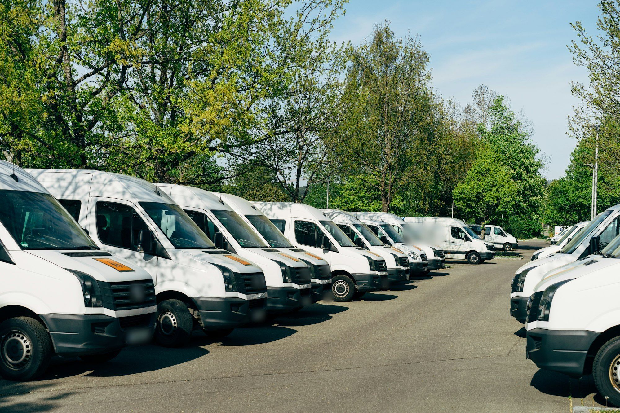 Row of white service vans in the shop lot