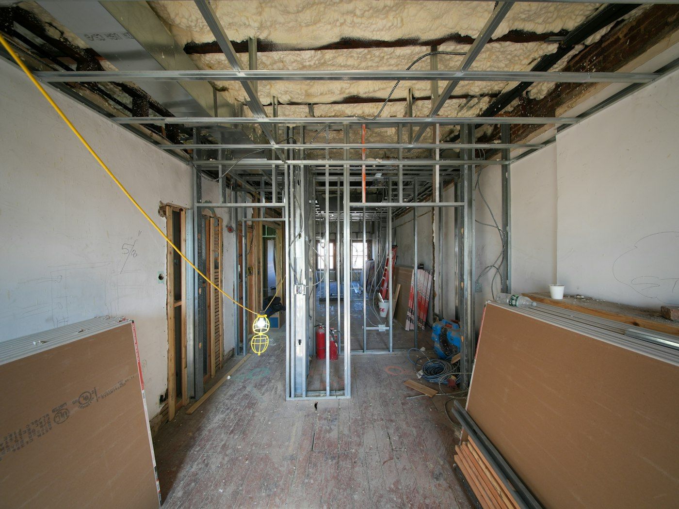 Drywall sheets stacked against new framing