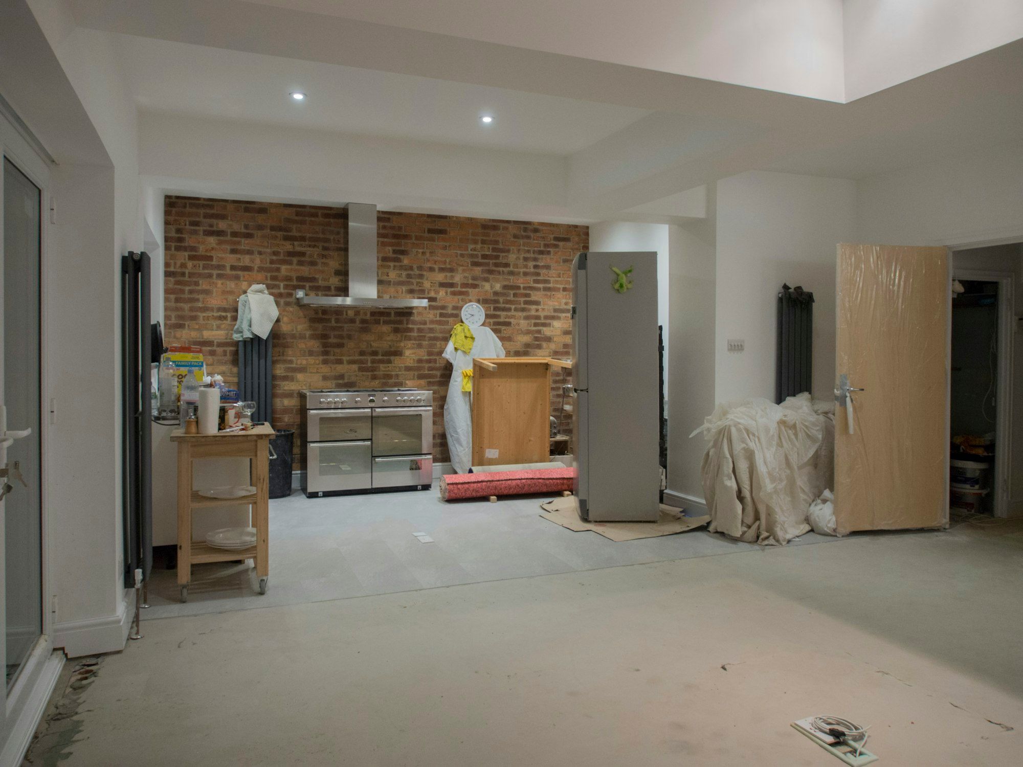 Kitchen space stripped to bare floor and walls during demolition