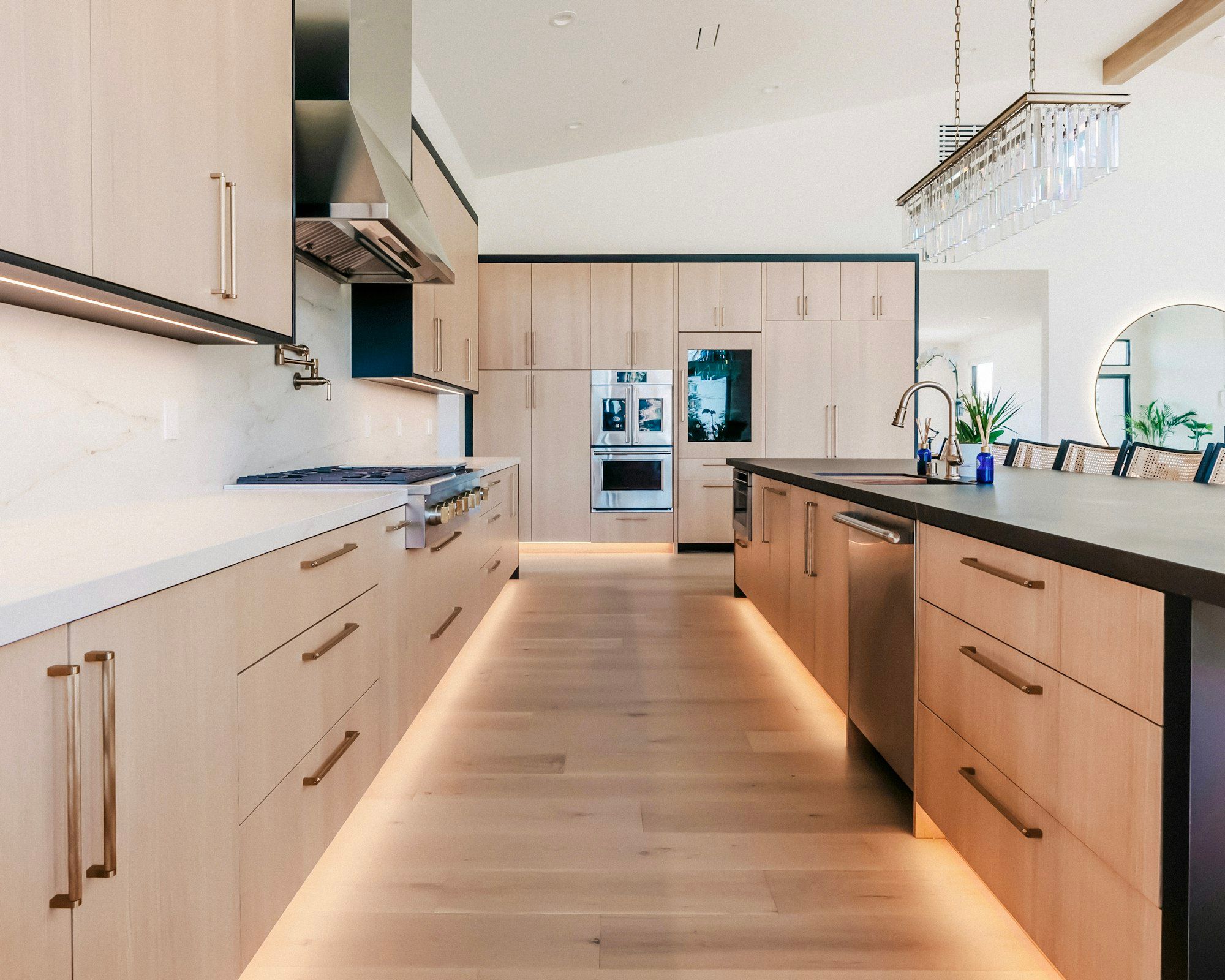 Light oak kitchen with a long island and toe-kick lighting