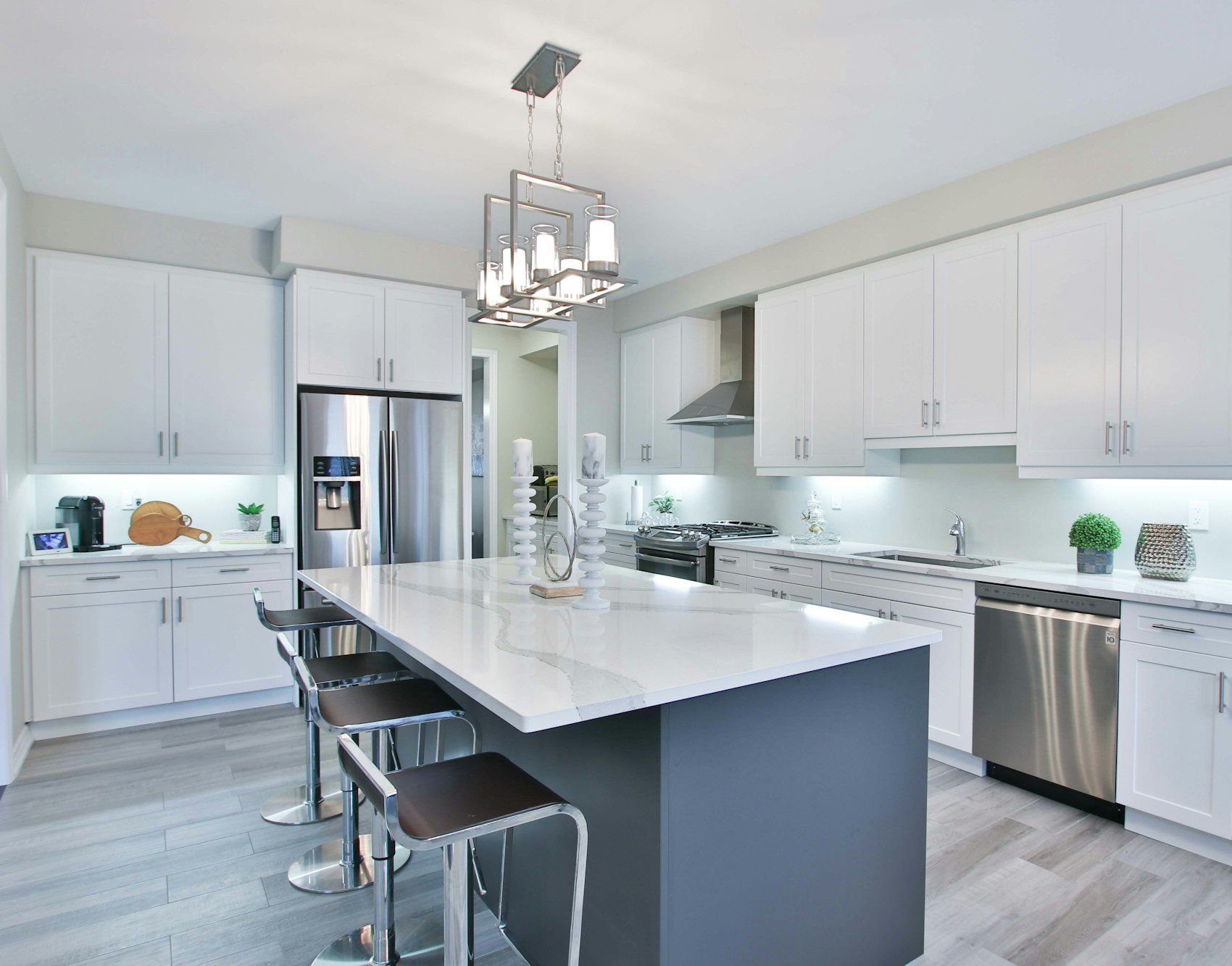 White kitchen with a dark gray island and bar stools