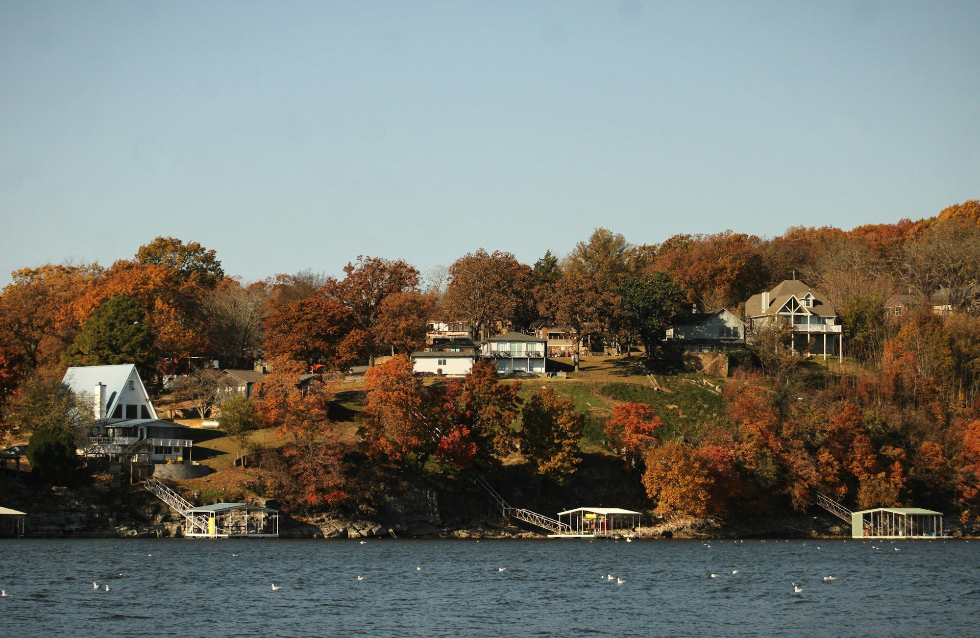 Homes on a wooded hillside above Crane Lake in autumn