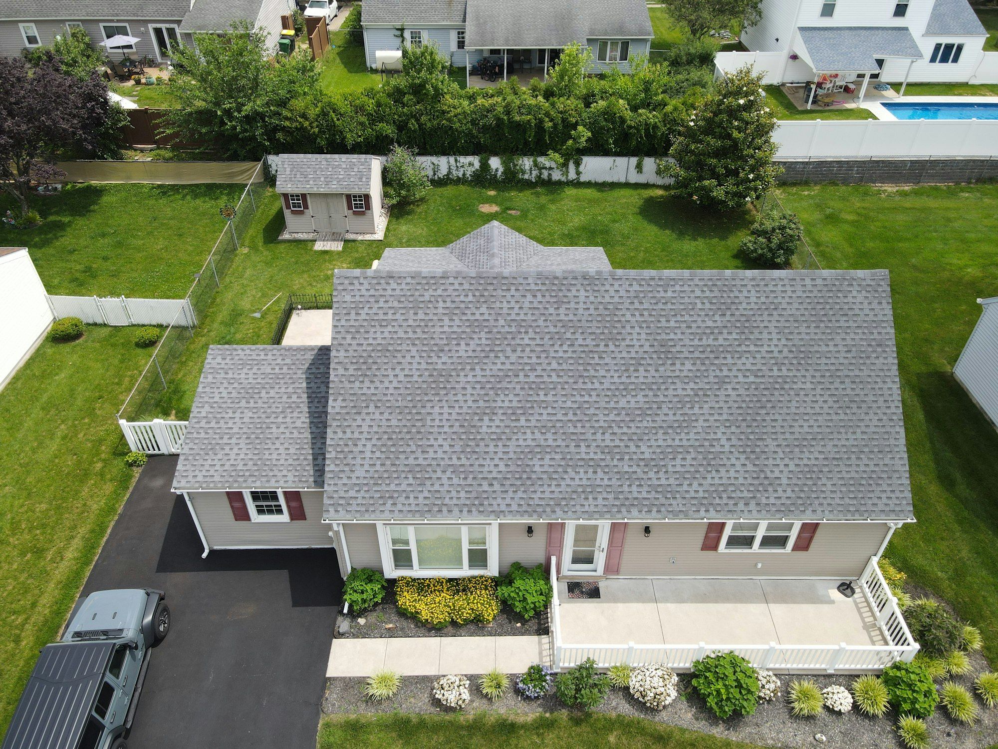 Aerial view of a single-story ranch house with a new grey architectural shingle roof