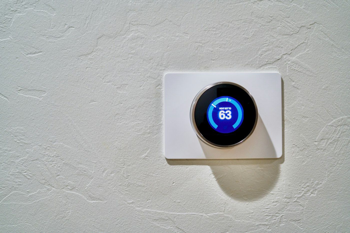 Round wall thermostat set to heat