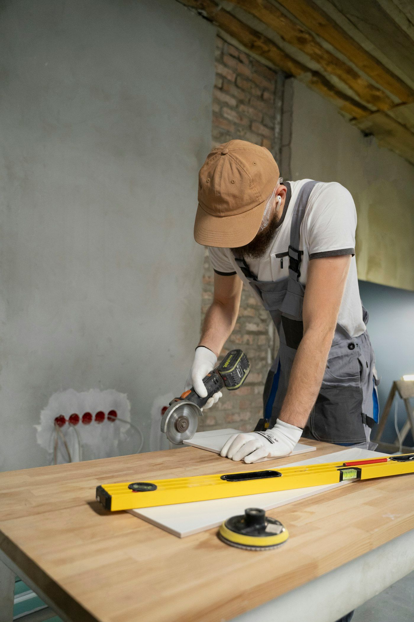 Raj cutting a porcelain tile on a butcher-block bench