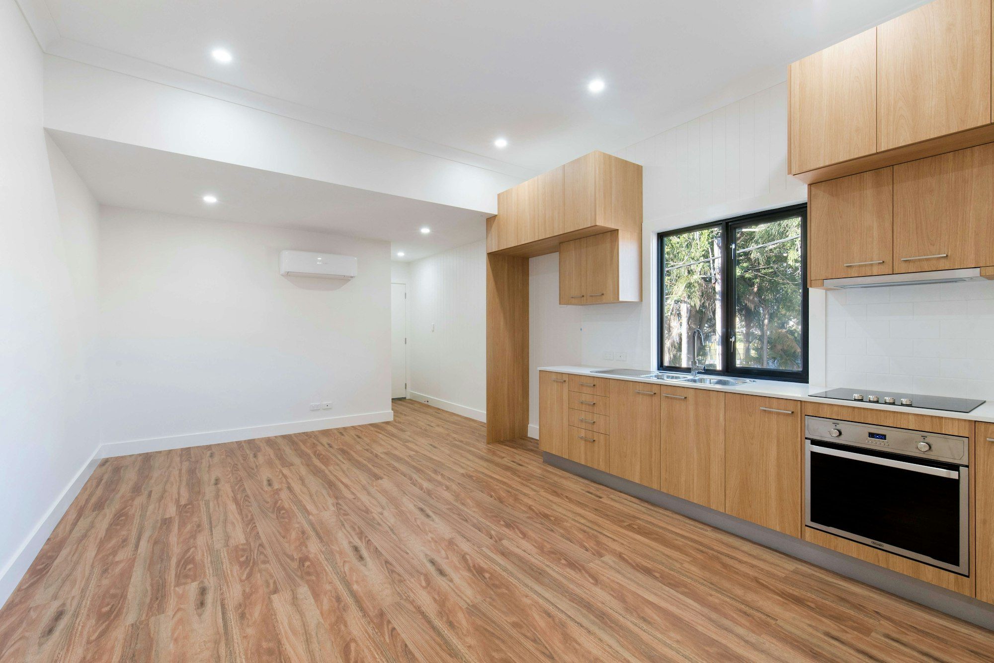 Kitchen and living area with warm chestnut vinyl plank floor